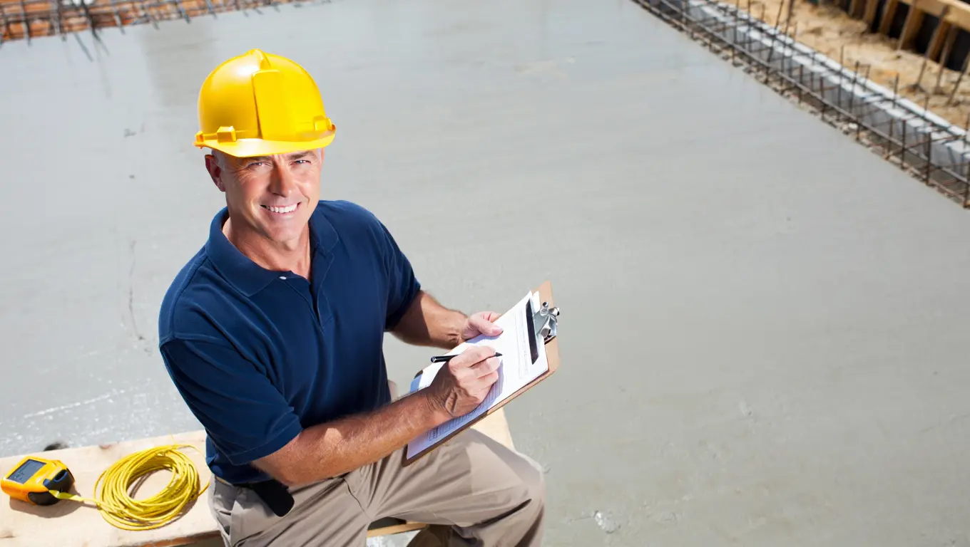 Project manager figuring yards of concrete and calculating the price of concrete per yard on a construction site.